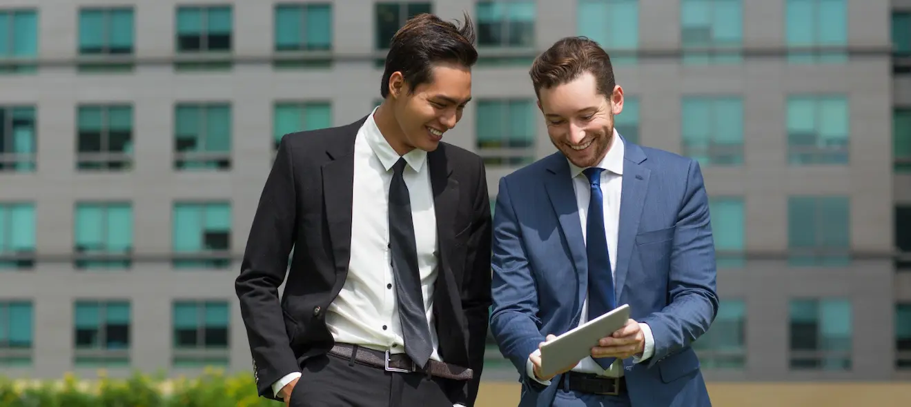 Two business professionals discussing sustainability and ESG initiatives outside a modern office building